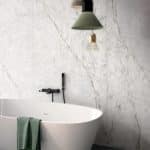 Icicle marble-look porcelain behind a freestanding bath and pendant light