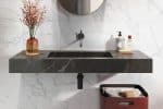Sicily Ice marble-look porcelain wall above a dark stone basin
